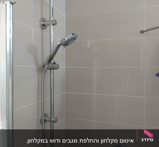 ראש מקלחת וכיור בחדר אמבטיה